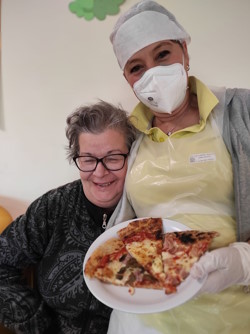 Responsabile di ristorazione con ospite e piatto con spicchi di pizza