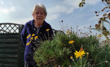 Ospite che sorride vicino a fiori